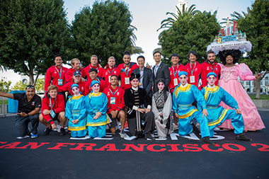 The Hong Kong Commissioner for Economic and Trade Affairs, USA, Mr Eddie Mak (back row, 6th from left); the Director of the Hong Kong Economic and Trade Office, San Francisco, Mr Ivanhoe Chang (back row, 7th from left) with the Hong Kong Team,  a cast member of San Francisco's Beach Blanket Babylon and the Cantonese opera troupe from Hong Kong at the Nations Welcome Ceremony.